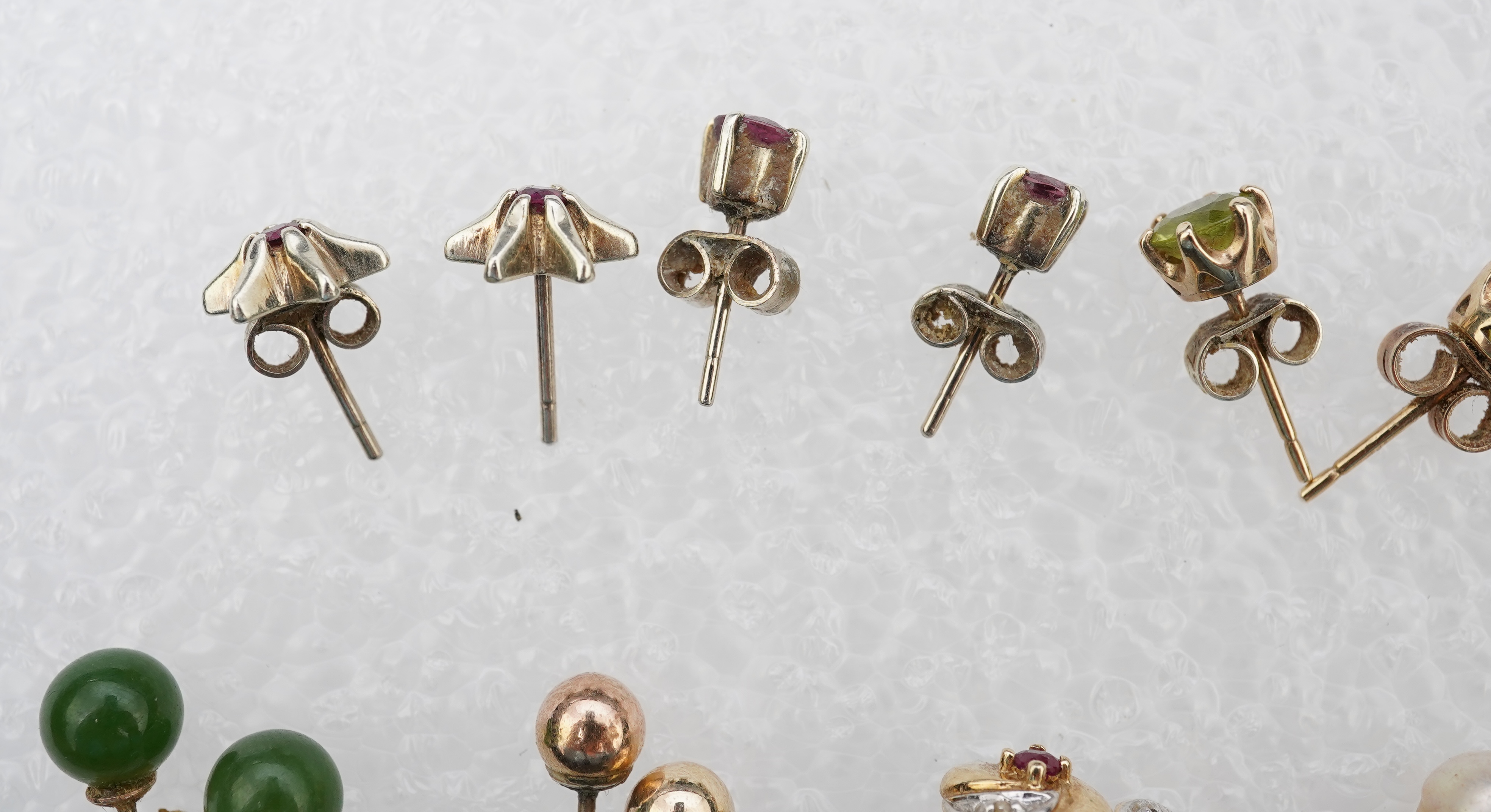 Four assorted pairs of 9ct and gem set ear studs including peridot and cultured pearl, together with three other assorted pairs yellow or white metal ear studs and two odd ear studs.